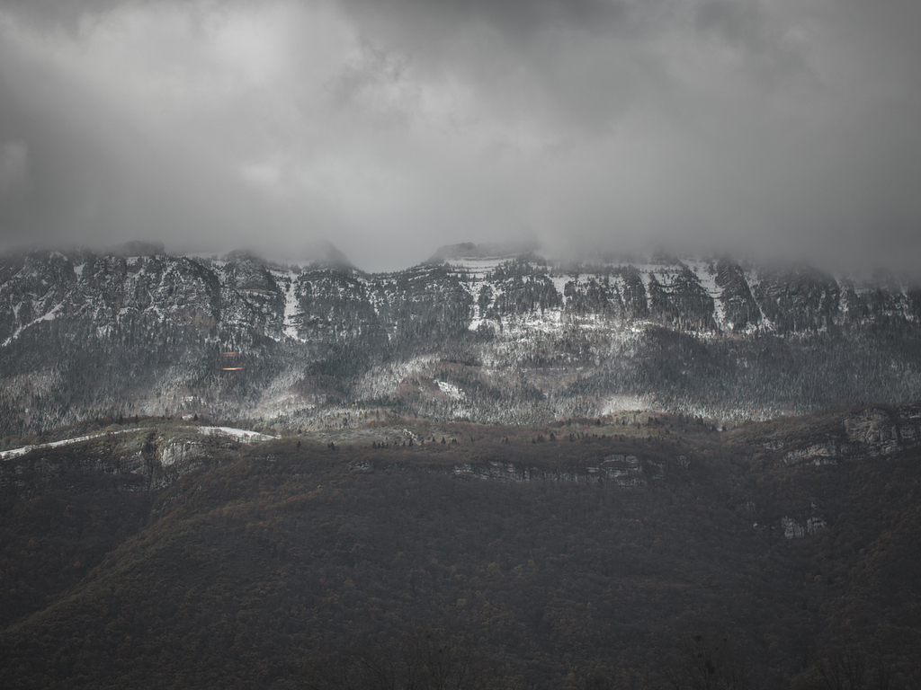 灰蒙蒙的天空下灰山附近的青草田
