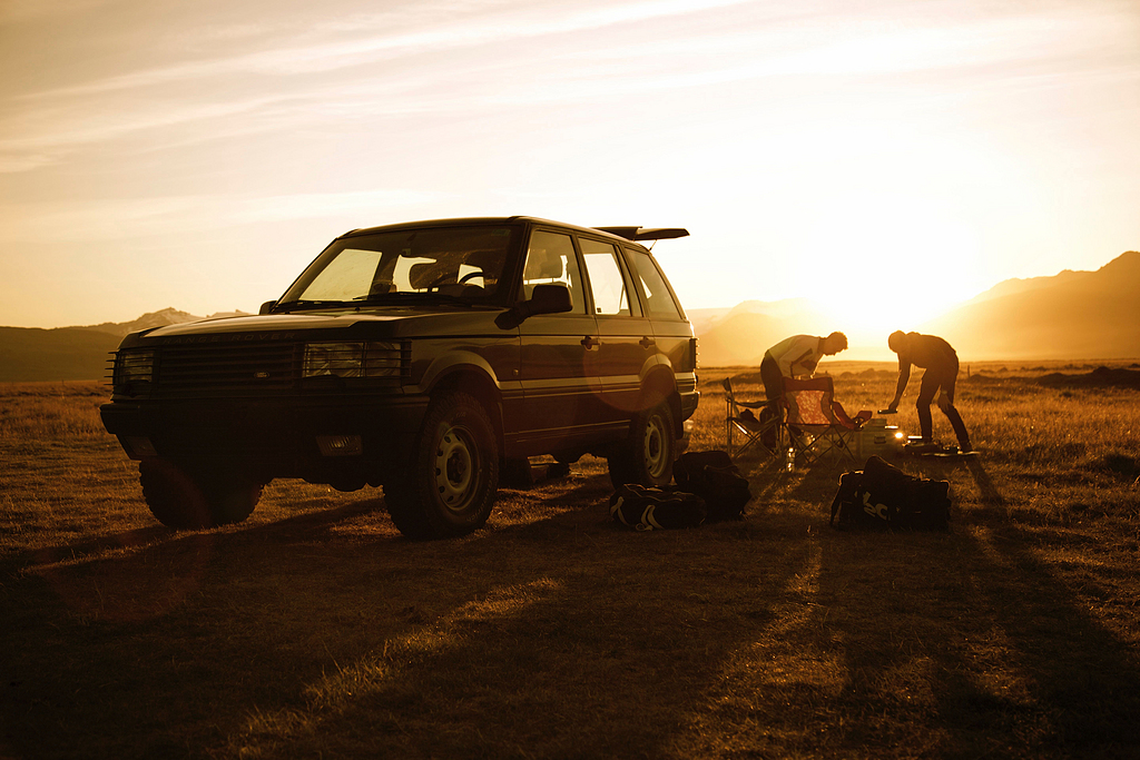 两个人站在一辆车的后面