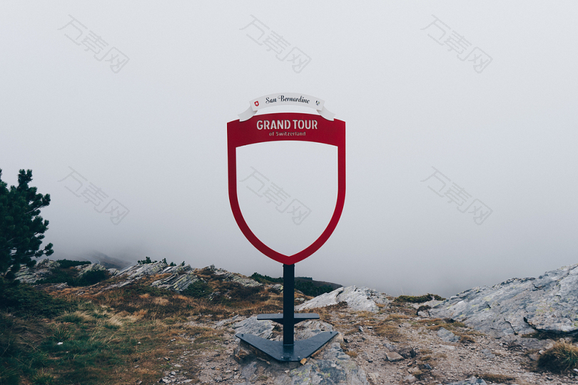 绿色植物附近的红色大旅游标志