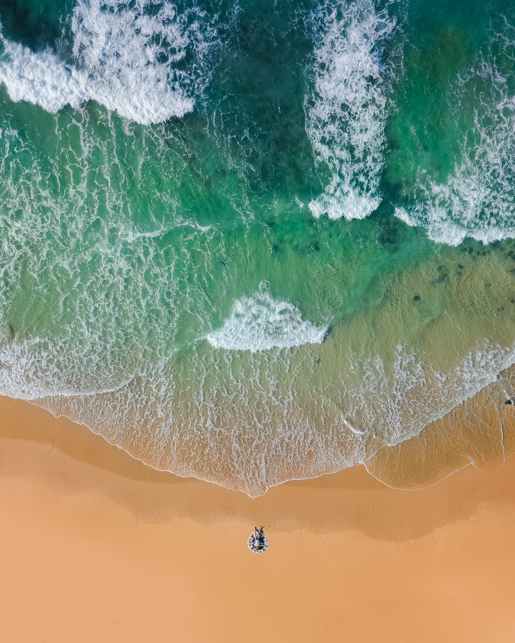 白天海水中海滩褐沙河的俯视摄影